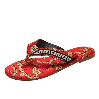 Stylish red and brown patterned slippers by Raspberry Eurybia showcasing a vibrant floral motif and a metallic accent on the strap.