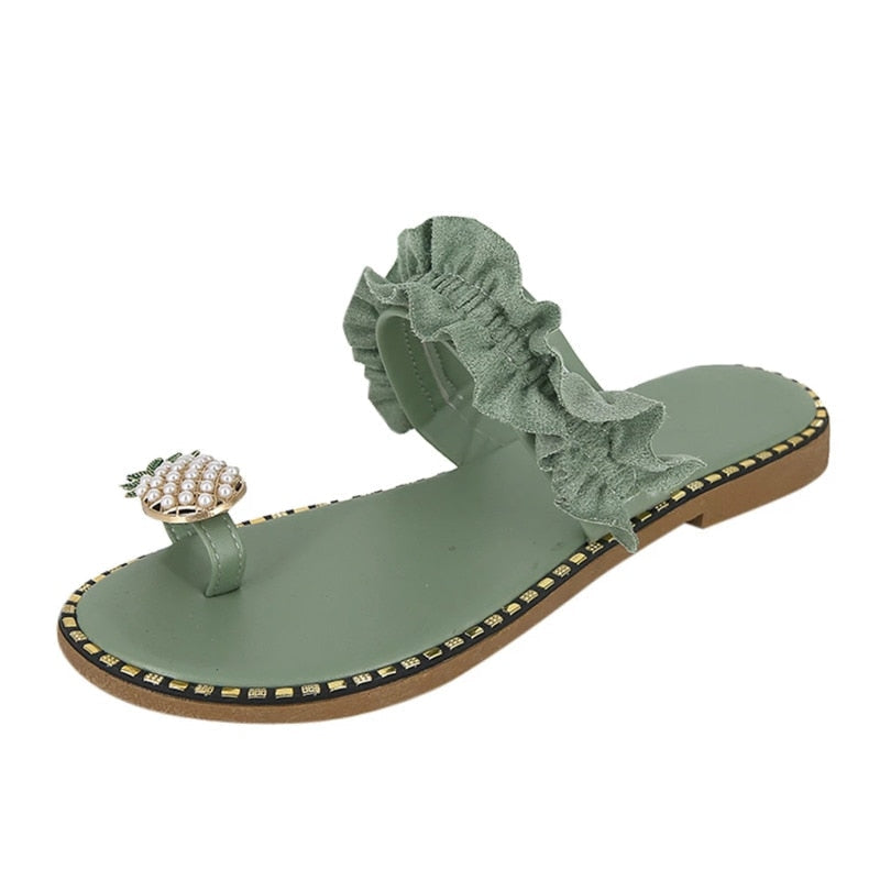 Pineapple pearl embellished green suede sandals with ruffle detail and flat, casual slipper design for women.