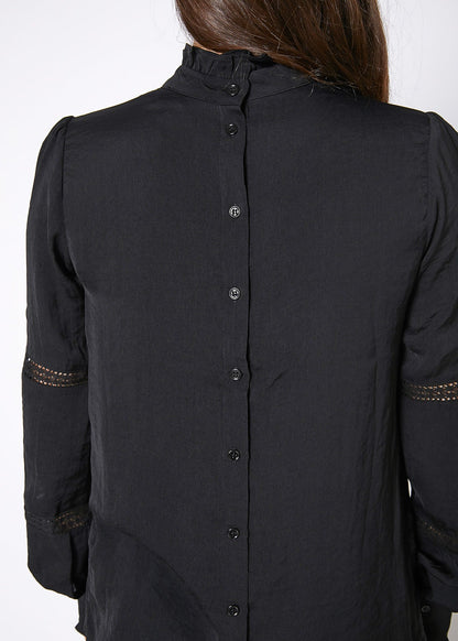 Elegant women's black blouse with long sleeves and eyelet detailing along the cuffs, photographed against a plain background.