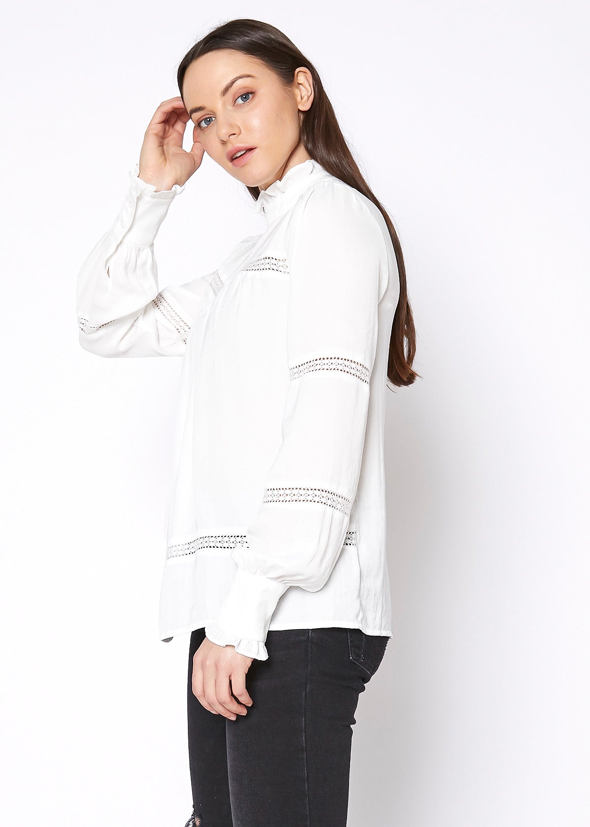 White women's eyelet long sleeve mock neck top with delicate embroidered details.