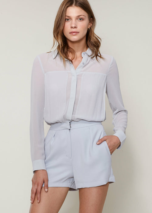 Slate-colored women's pleated button-up romper with long sleeves, tailored fit, and neutral tone.