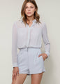 Slate-colored women's pleated button-up romper with long sleeves, tailored fit, and neutral tone.