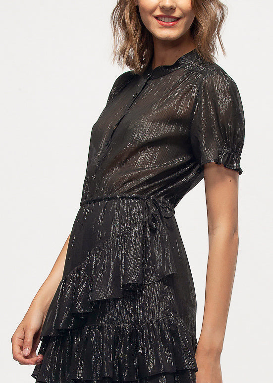 Elegant black lurex dress with ruffled detail, capturing the model's stylish appearance on a white background.