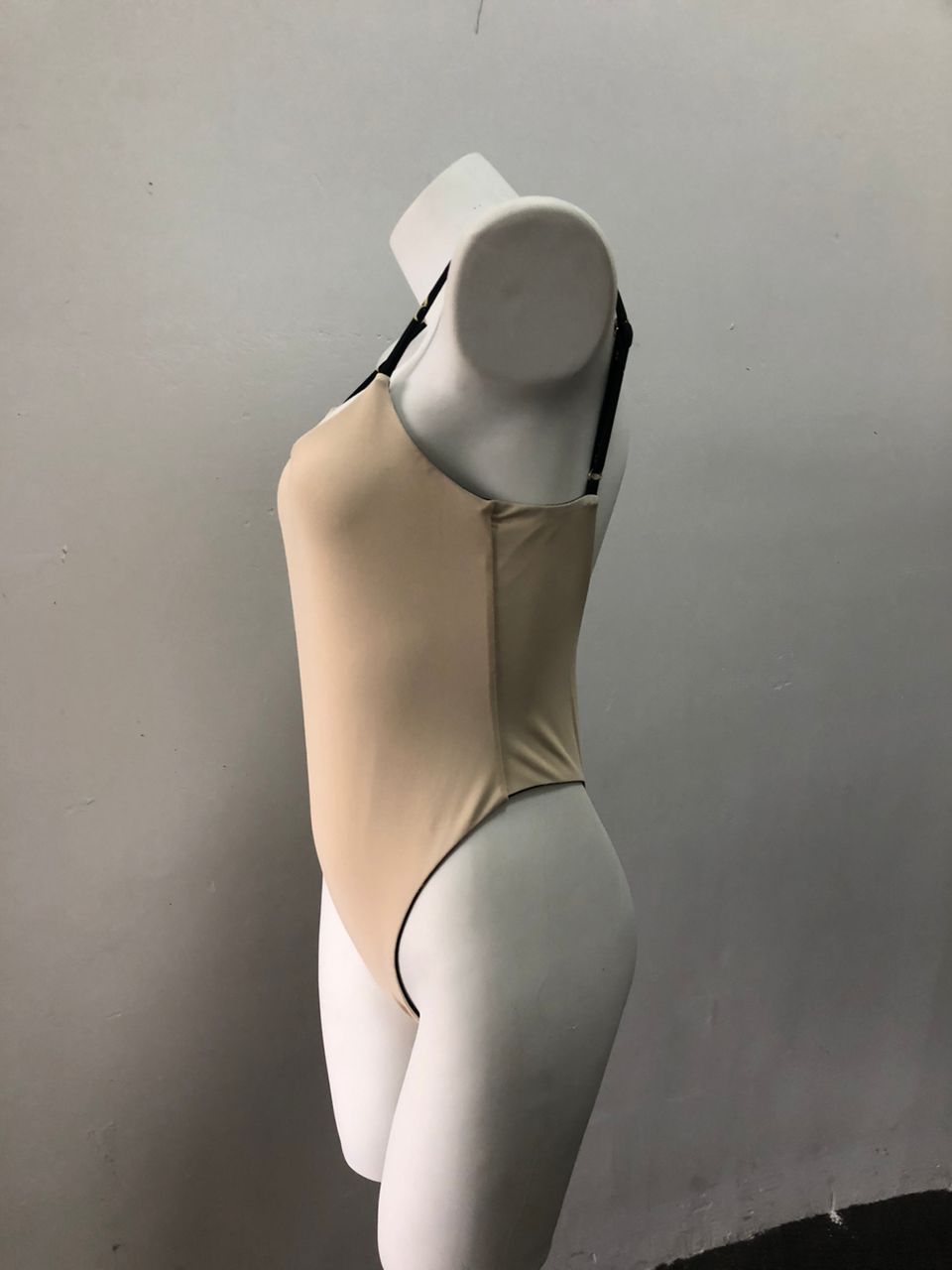 Elegant nude-tone swimsuit with minimalist design, showcasing sleek, flattering silhouette on display.