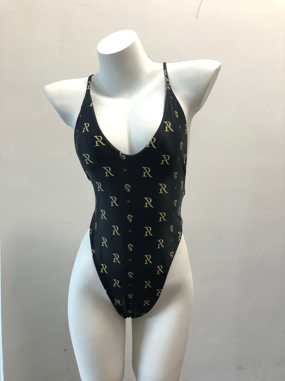 Sleek black swimsuit with elegant gold print, showcasing stylish design for the modern woman.