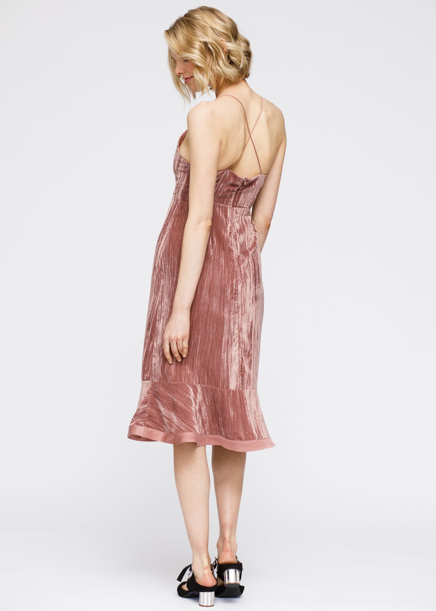 Stunning velvet spaghetti strap dress with ruffled hem and midi length, showcasing a fashionable and feminine silhouette.