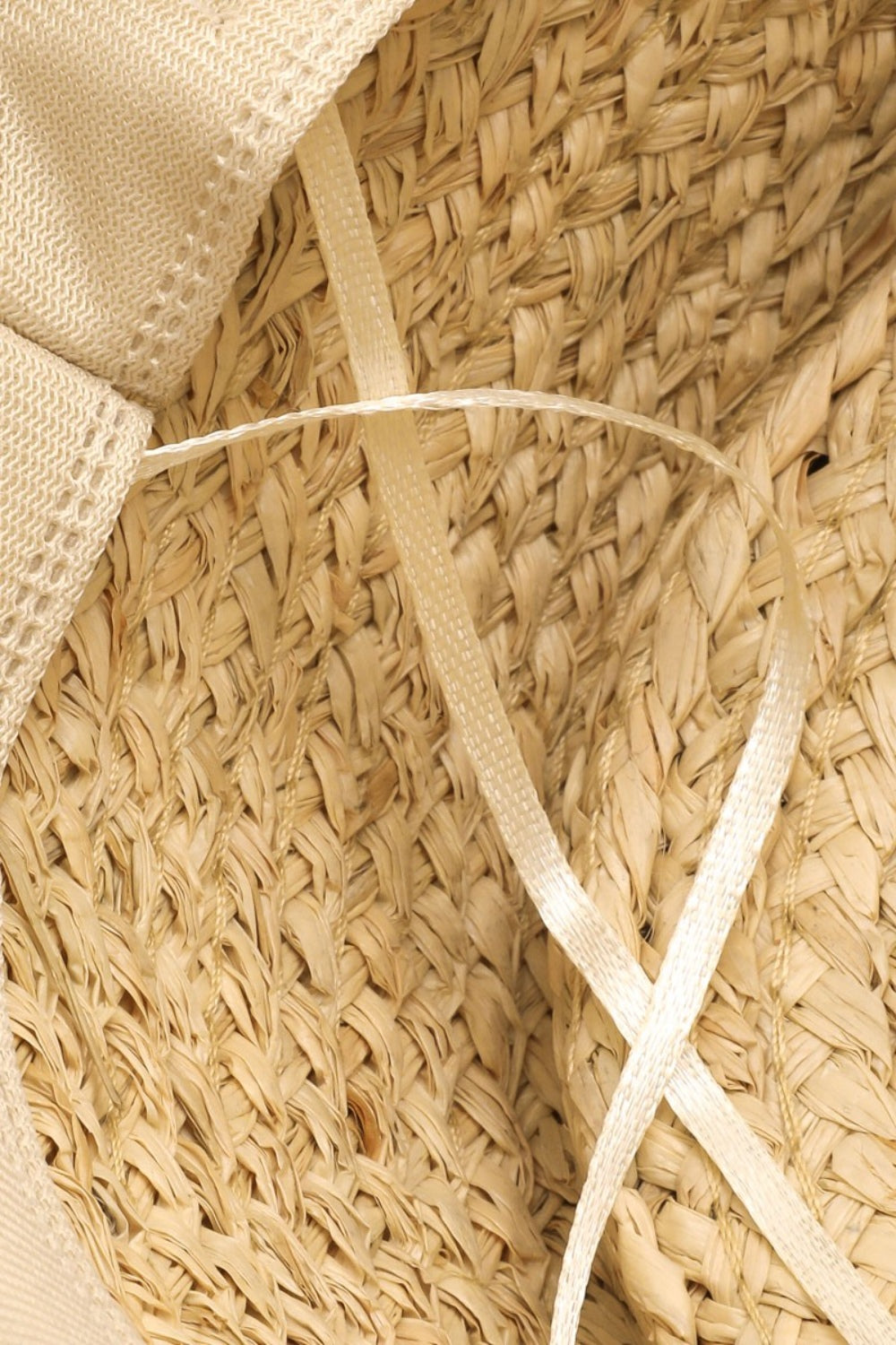 Wide-brimmed straw hat with intricate woven textures and elegant cream fabric detailing