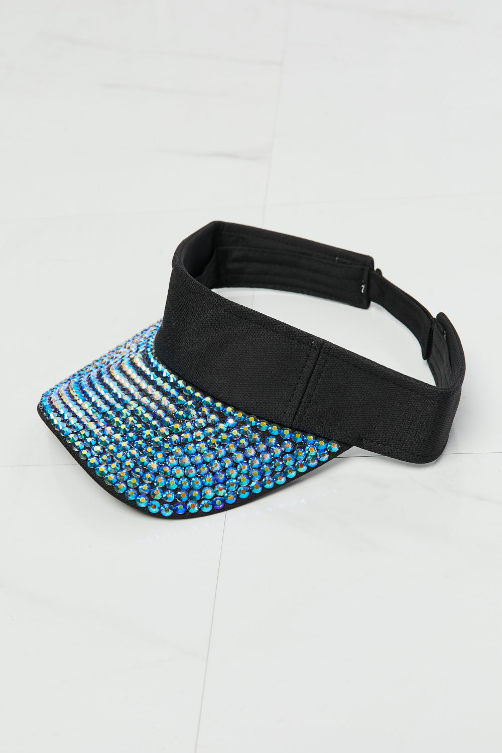 Sparkly Blue Rhinestone Visor Hat - A black, adjustable visor hat with a panel of vibrant blue rhinestones covering the front, creating an eye-catching and fashionable accessory.