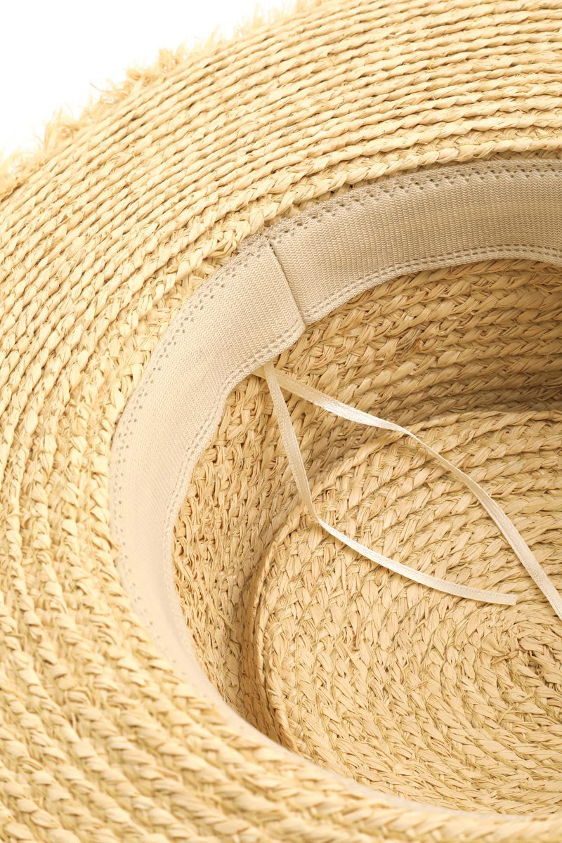 Beige straw hat with adjustable strap and raw edge design, showcasing the intricate woven texture of the natural material.