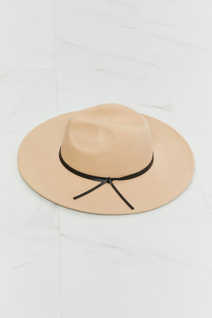 Stylish beige fedora hat with black band for versatile fashion