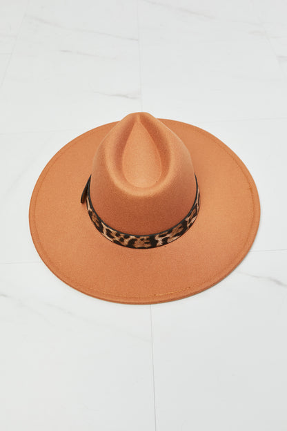 Fashion-forward orange fedora hat with animal print band, perfect for a day out in the wild.