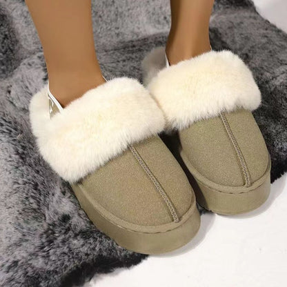 Plush platform slippers with white fluffy trim and a strap accent, resting on a soft gray background.