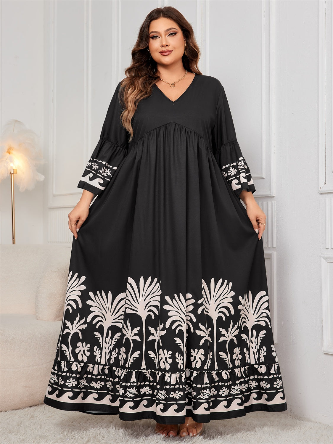 Elegant plus-size floral-printed black maxi dress with long sleeves, V-neck, and flowing silhouette.