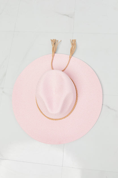 Stylish pink straw hat with woven accents, ideal for summer travels and outdoor adventures.