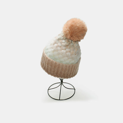 Cozy Gradient Knit Hat with Pompom
This image shows a stylish knit hat with a gradient pattern and a plush pompom on top. The hat is displayed on a simple metal stand, showcasing its textured and warm design.