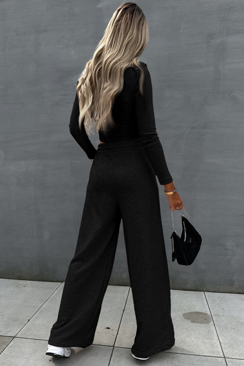 Elegant black crop top and wide-leg pants two-piece set on blonde-haired woman