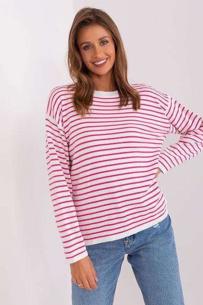 Striped knit jumper featuring vibrant red and white hues, worn by a smiling young woman with long brown hair.