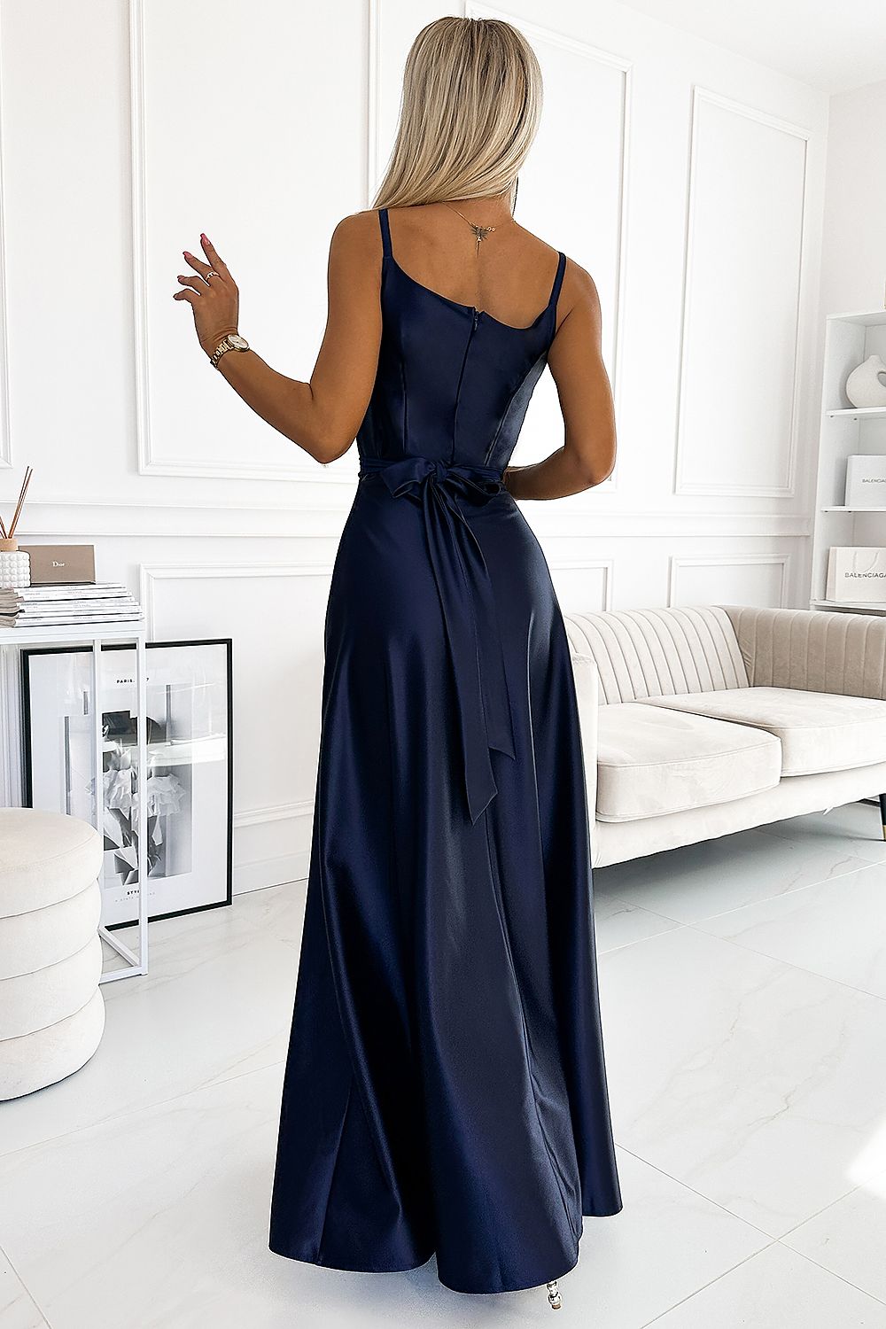 Elegant navy blue women's evening gown with lace detailing, adjustable straps, and a flowing skirt.