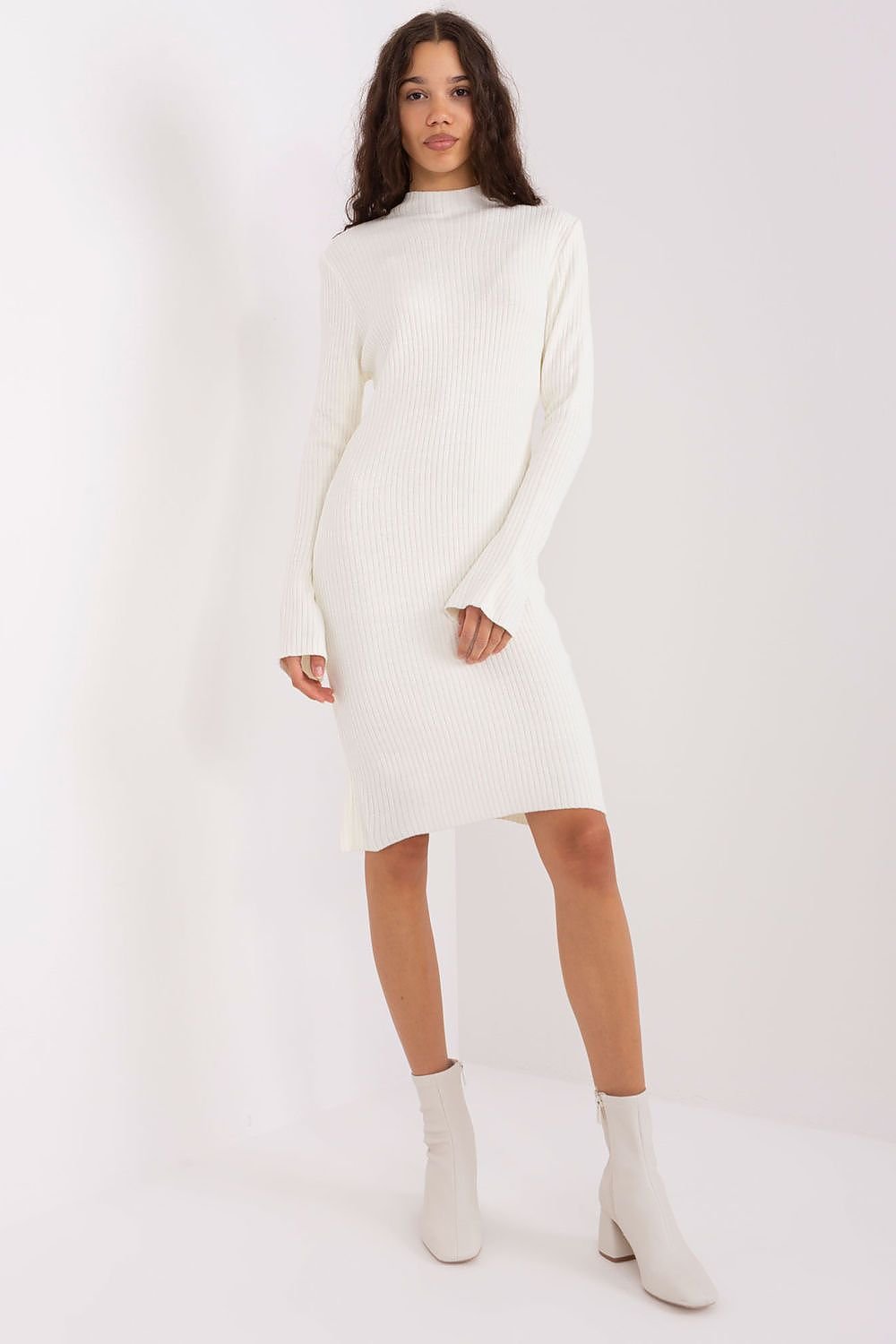 Elegant white knit dress with long sleeves, worn by a female model on a plain background.