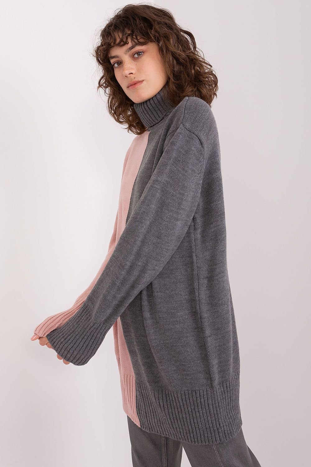 Cozy gray turtleneck sweater, stylish model with curly hair posing against white background.