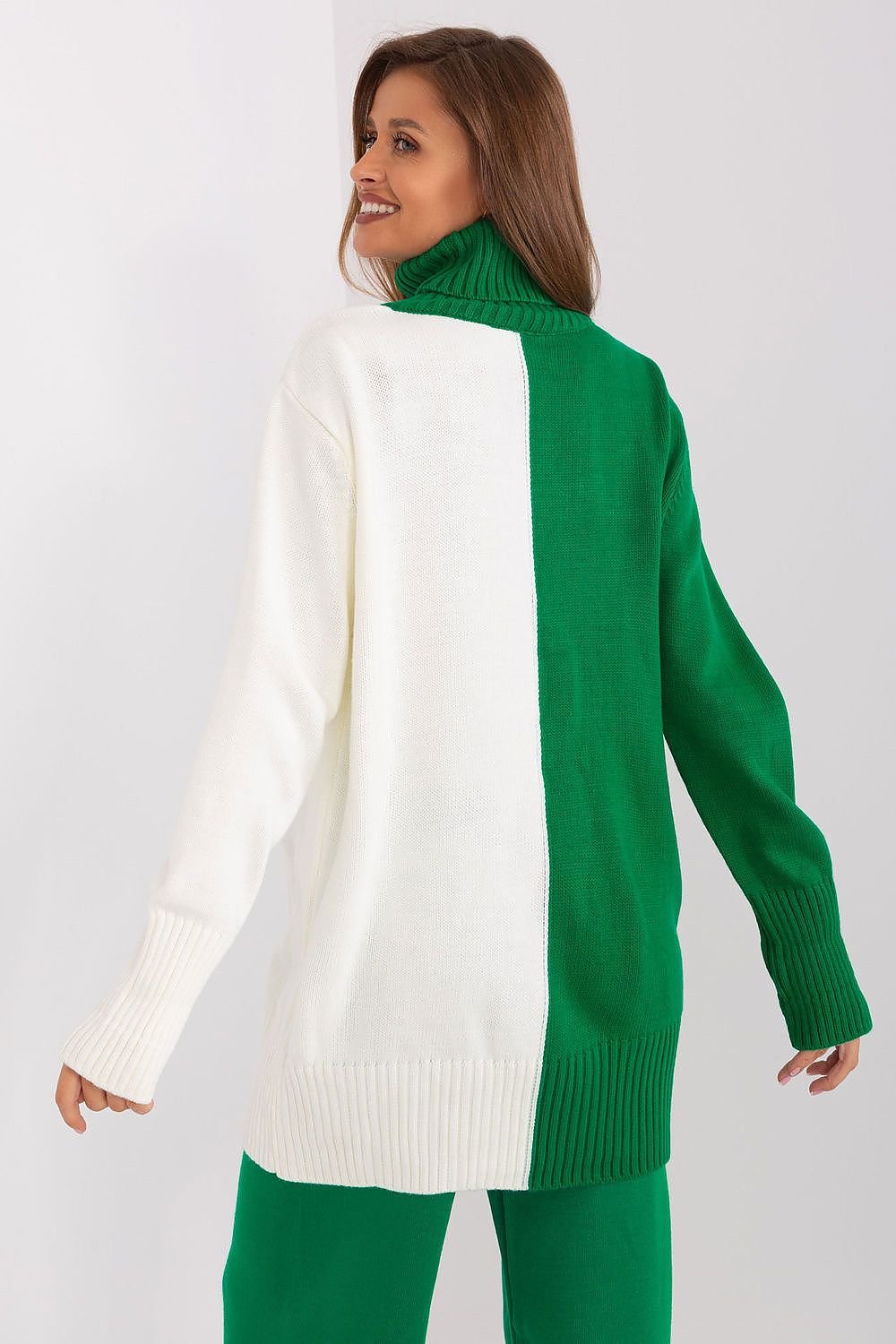 Stylish green and white turtleneck sweater with ribbed details, worn by a young woman against a plain background.