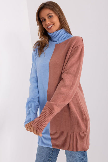 Stylish knit turtleneck sweater with color block design in blue and pink, worn by a smiling woman against a white backdrop.