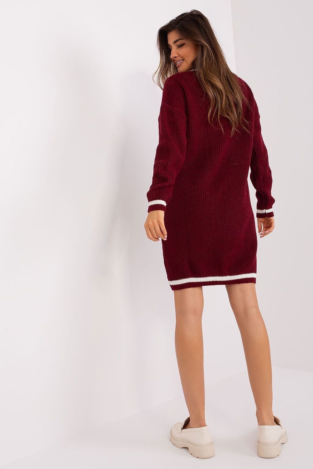 Stylish burgundy knit dress with striped trim, worn by a young woman in the image.