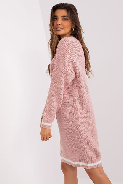 Soft pink knit dress with long sleeves and a relaxed, comfortable fit, showcasing the model's casual yet stylish fashion sense.