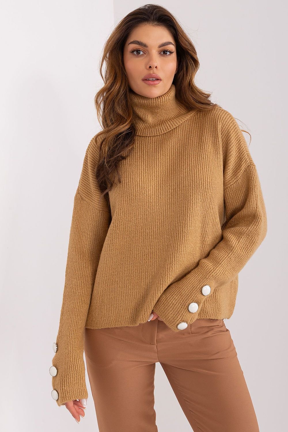 Cozy turtleneck sweater with stylish button accents, warm beige hue, and model in image.