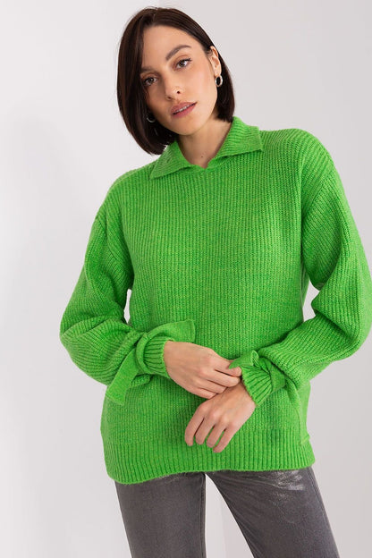 Bright green knitted jumper with ribbed texture worn by a young female model against a plain white background.