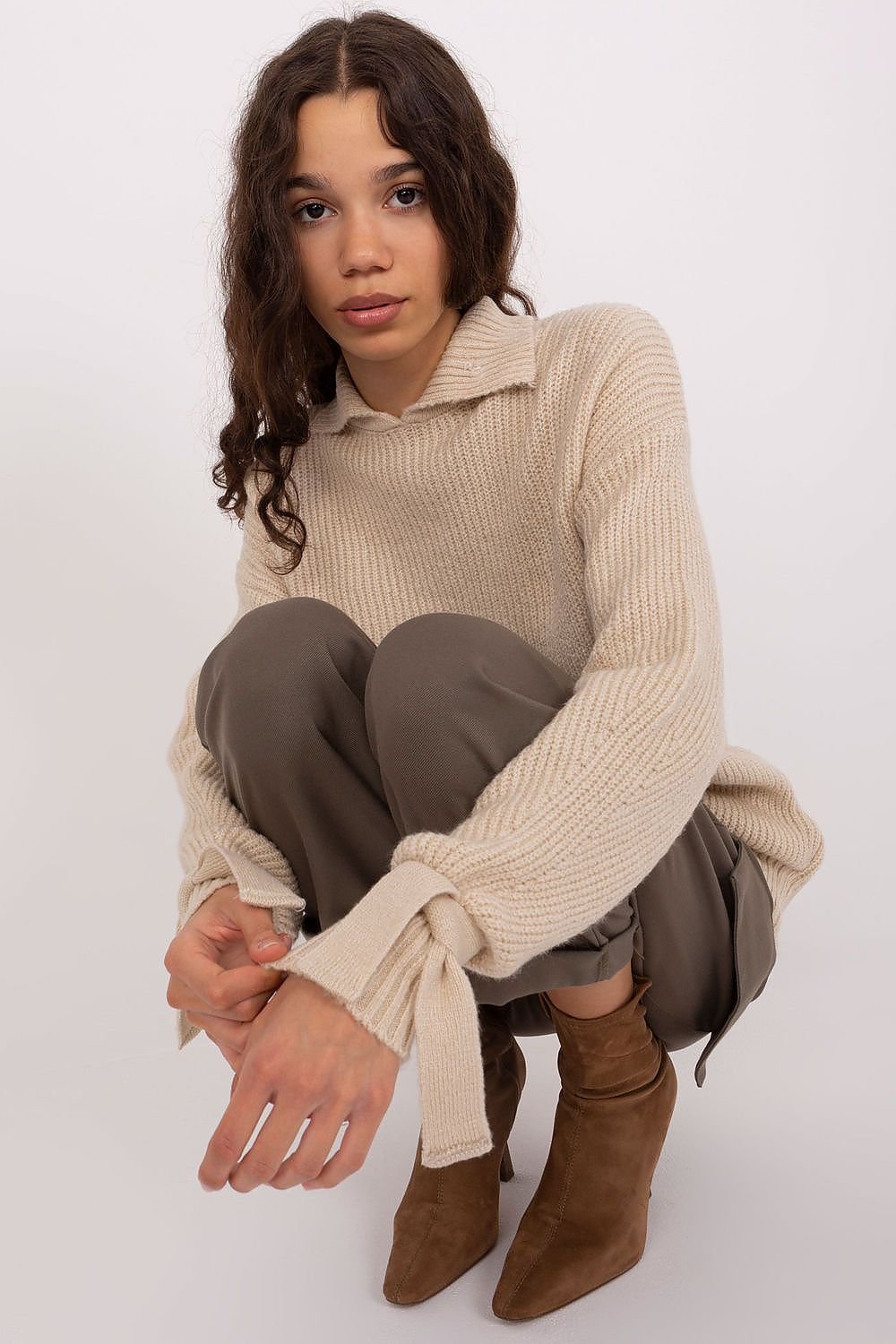 Cozy cream cable-knit sweater, taupe leggings, and suede ankle boots - a comfortable and stylish casual ensemble.