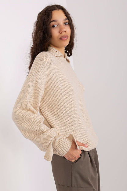 Cozy knitted beige jumper with loose fit and ribbed texture worn by young woman