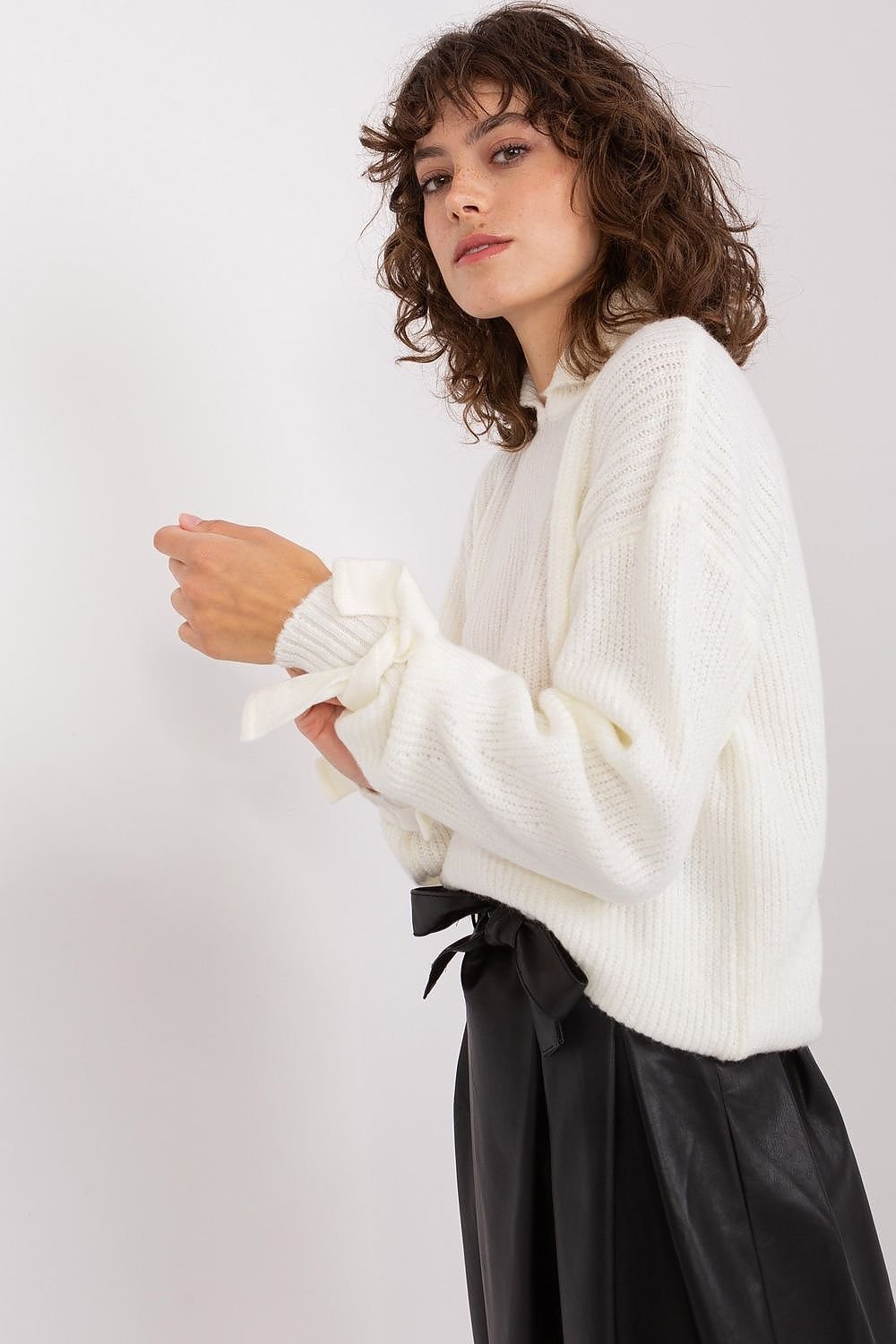 Cozy white jumper with soft, fluffy texture worn by a young woman with curly hair.