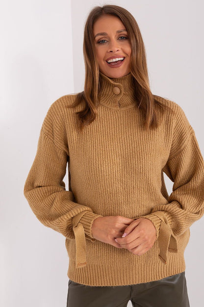 Snug and stylish camel-colored knitted jumper from the Badu brand, with a cozy turtleneck design and long balloon sleeves showcased on a smiling female model.