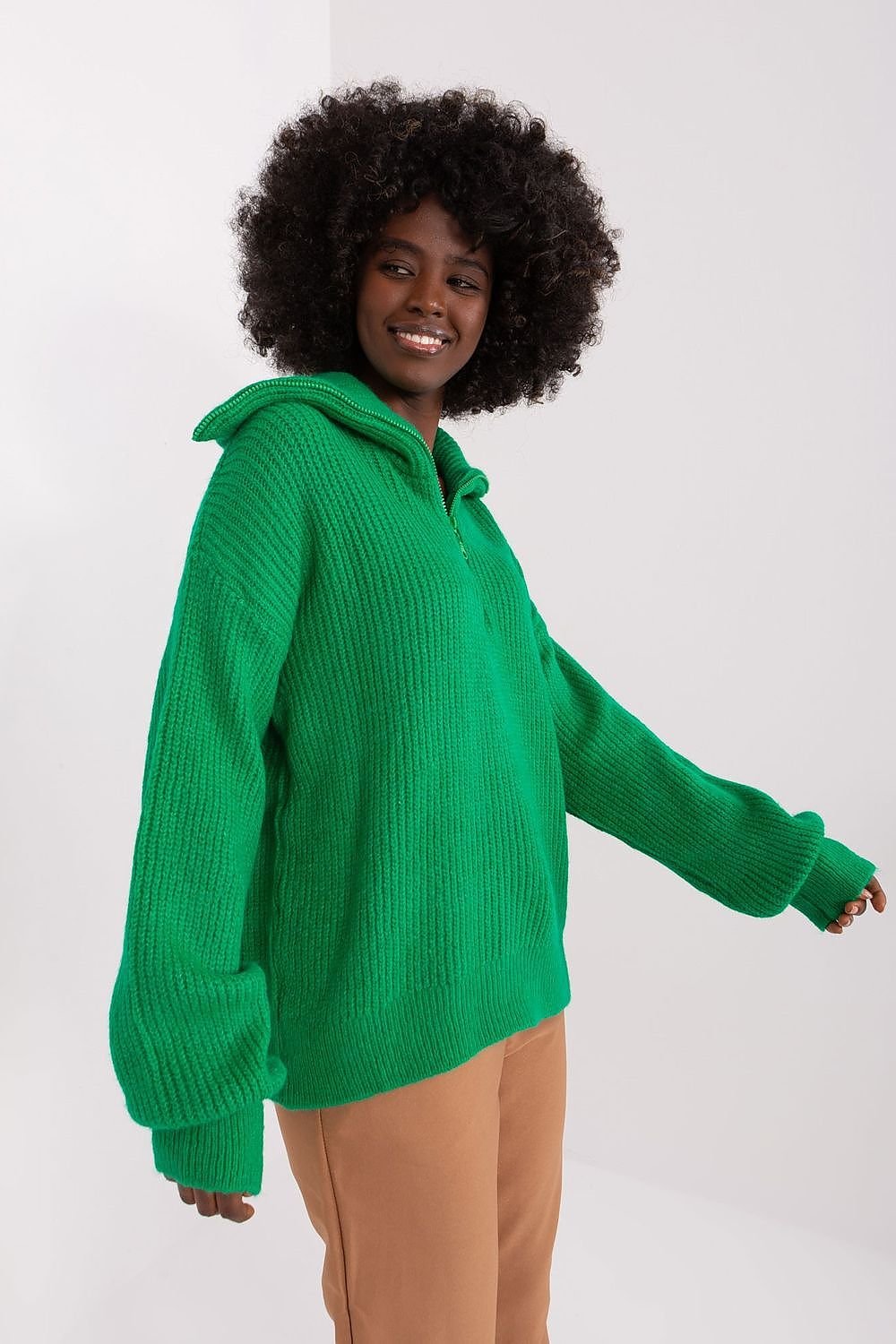 Vibrant green ribbed turtleneck pullover, worn by a smiling model with a curly afro hairstyle, on a plain white background