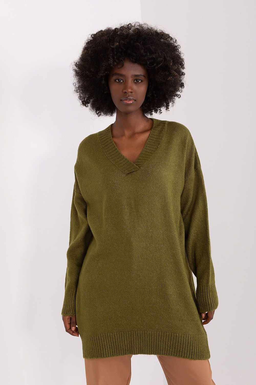 Cozy olive green knit jumper dress on female model with curly dark hair