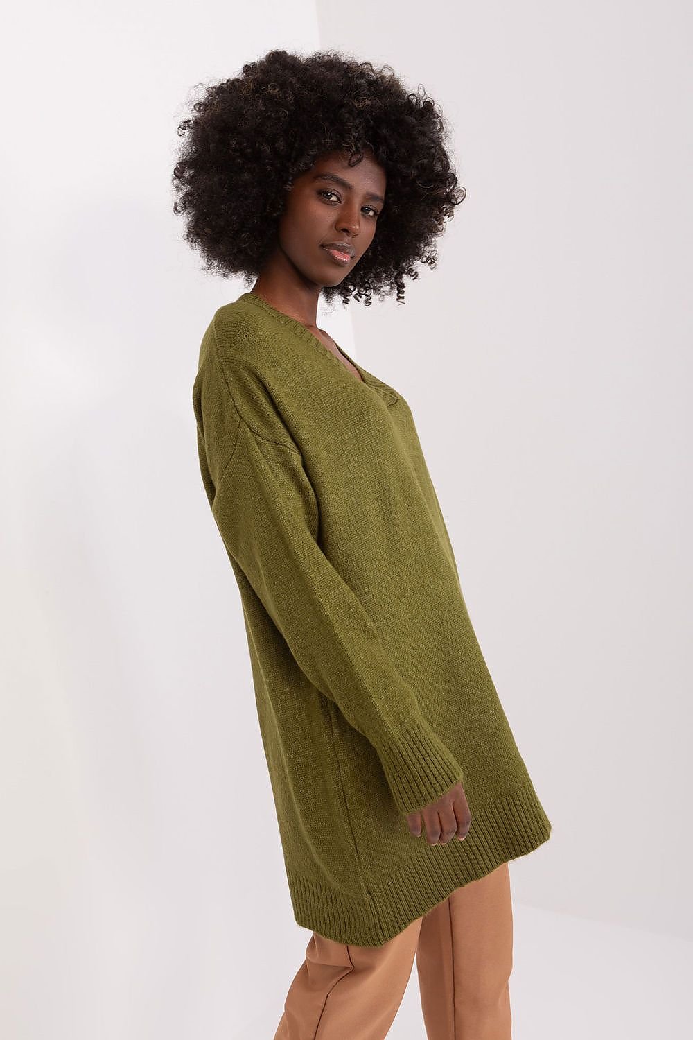 Olive green knit dress with long sleeves, worn by a woman with curly dark hair.