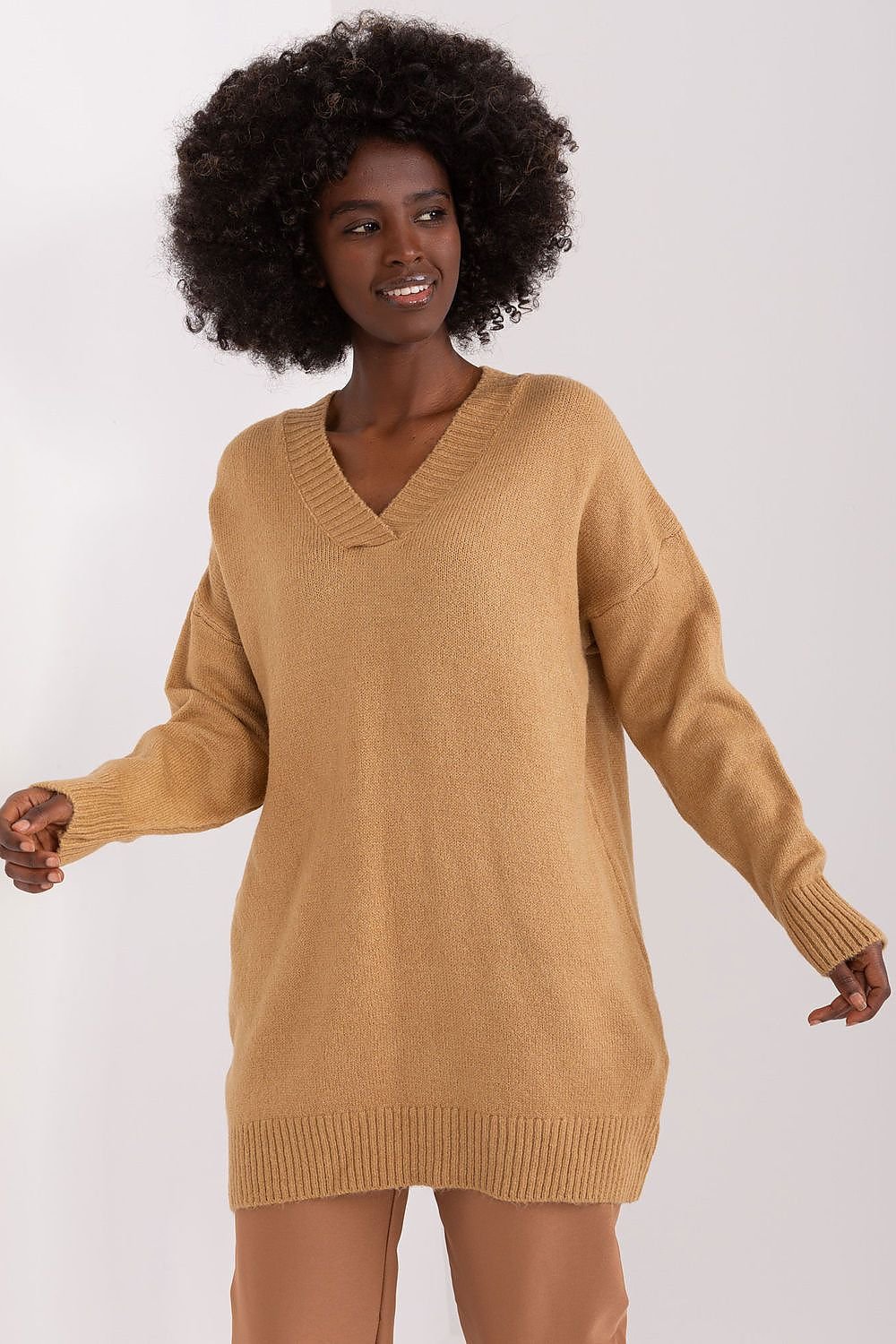 Cozy camel-colored v-neck sweater dress with curly dark hair model