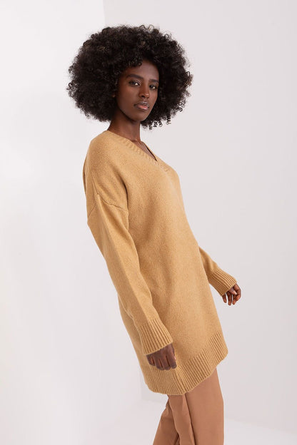 Curly-haired model wears cozy mustard-colored knitted jumper dress