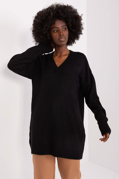 Cozy black knit dress with v-neck design, featuring a model with curly dark hair posing against a plain background.