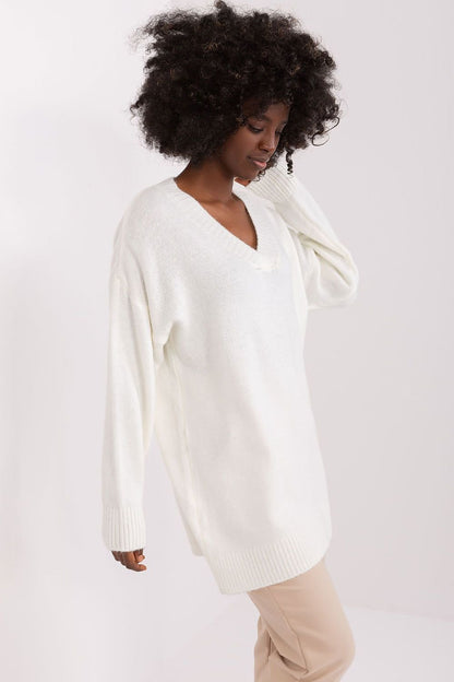 Cozy white knitted sweater dress featuring a deep v-neck design and long sleeves for a comfortable, stylish look.