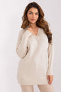 Cozy ivory knit jumper with deep V-neckline, worn by beautiful brunette model with wavy hair against a clean white background.