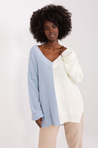 Stylish knit jumper with contrasting colors and textures, featuring a model with natural curly hair against a plain background.