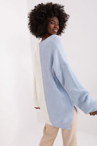 Curly-haired woman wearing a light blue ribbed knit pullover sweater