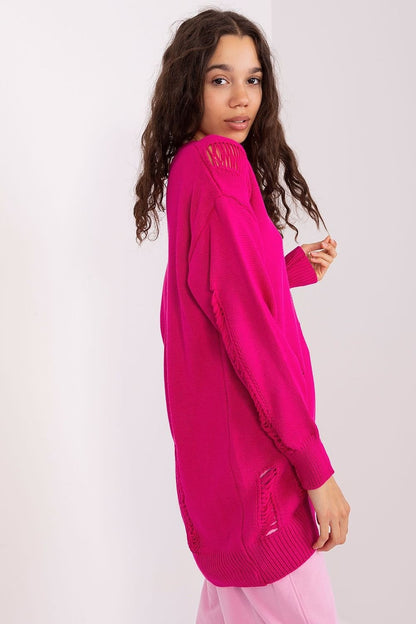 Stylish fuchsia pink cardigan with ribbed cuffs and hem, worn by a young woman with long curly brown hair against a plain white background.