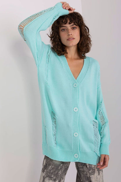 Lightweight mint green cardigan with button-up closure and long sleeves, worn by a young woman with curly dark hair.