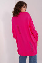 Load image into Gallery viewer, Bright pink oversized knitted cardigan with ripped details on a female model with curly brown hair.