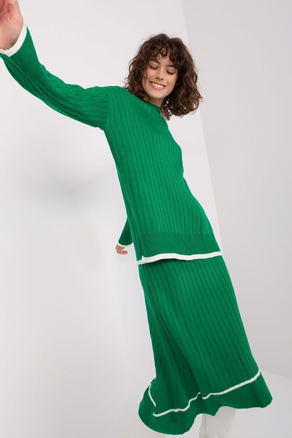 Elegant green ribbed midi dress with puff sleeves, featuring a smiling model with curly hair posing against a white background.