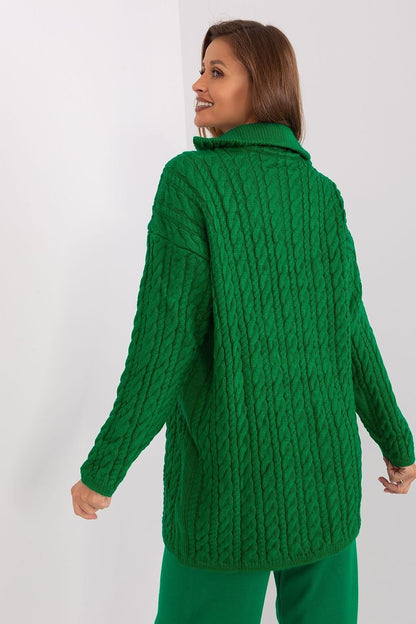 Warm, cozy green knit cardigan with intricate cable-knit pattern, worn by a woman with long brown hair in a white studio setting.