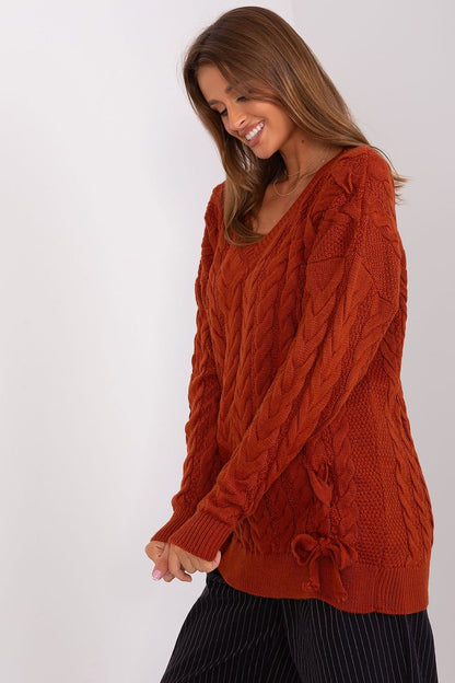 Elegant knit sweater dress by Badu featuring cable knit pattern in rust orange color.